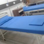 A close-up view of neatly folded white Indian cotton hospital linens placed on a bed in a Latin American healthcare setting, symbolizing softness, hygiene, and comfort.